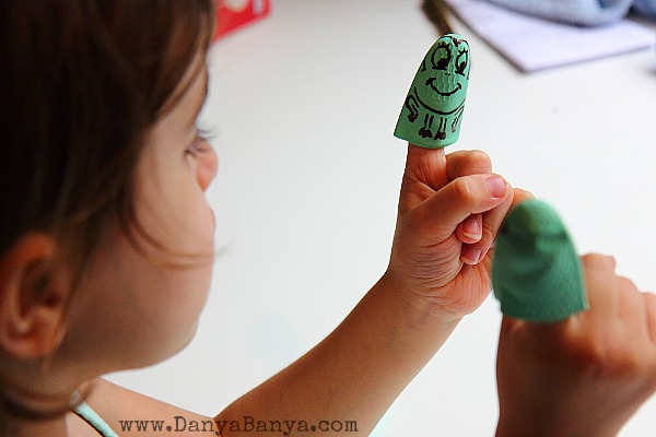 JJ playing with two of the rubber glove frog puppets