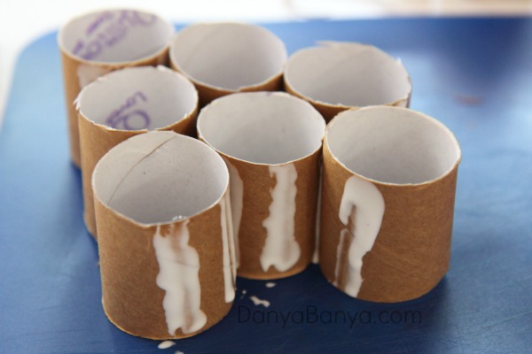 Cut and glue the toilet paper rolls into the shape of a Christmas tree