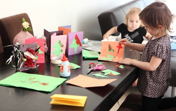 Cutting and gluing kids artwork for homemade Christmas cards that preschoolers can make ~ Danya Banya