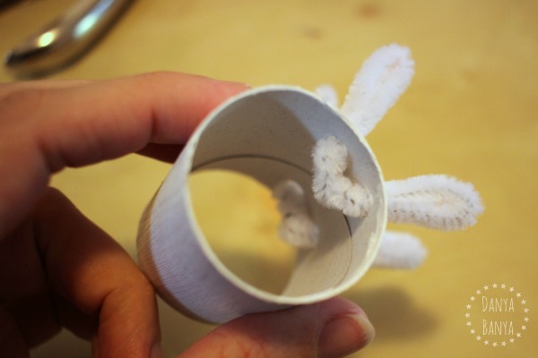 Adding chenille pipe cleaner legs to the toilet paper roll sheep