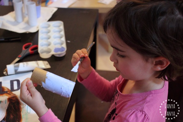 Girl painting a toilet paper roll doll