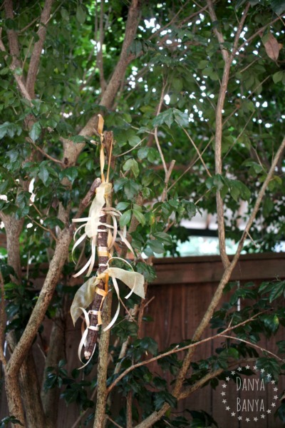 Gold Ribbon Stick Ornament hanging up in a tree