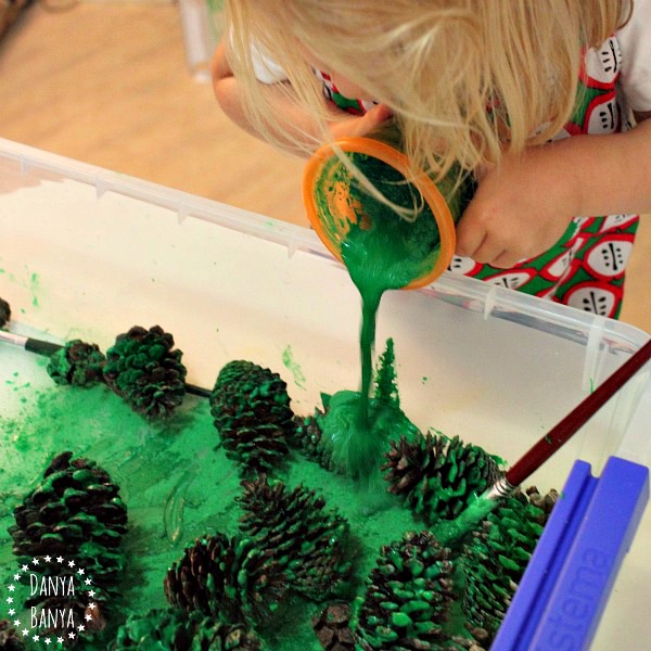 Painting pine cones with green tempera paint